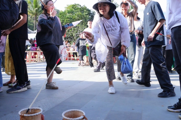五指山市毛纳村村民用本地民族特色的春节民俗吸引游客前往打卡。